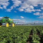 John Deere M4030 self-propelled sprayer applying crop protection in a South African field as it drives toward the camera — built for precision and performance.