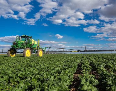 John Deere M4030 self-propelled sprayer applying crop protection in a South African field as it drives toward the camera — built for precision and performance.