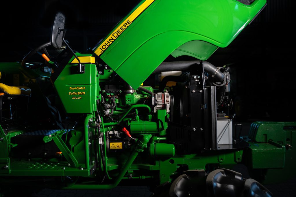 A photo of the engine and open hood of a John Deere 5050D tractor.