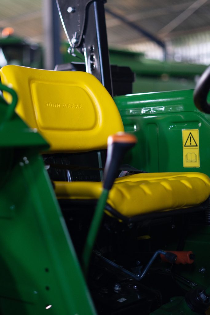 A photo of a yellow, adjustable deluxe vinyl seat that comes standard in the John Deere 5E Series tractors.