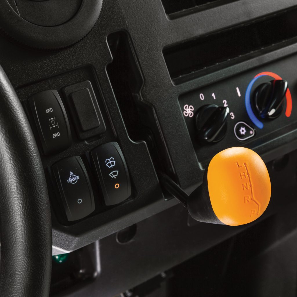 A close-up photo of the gear lever and switches of the John Deere XUV 875M Diesel.
