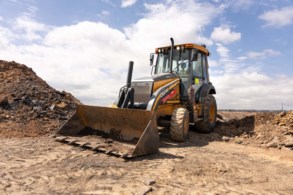 Fleet of John Deere machines, including the 310 P-Tier TLB, at a South African mine.