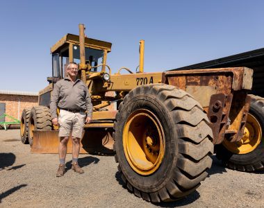 Photo of the old John Deere 770A Motor Grader with a representative of Elite Guys