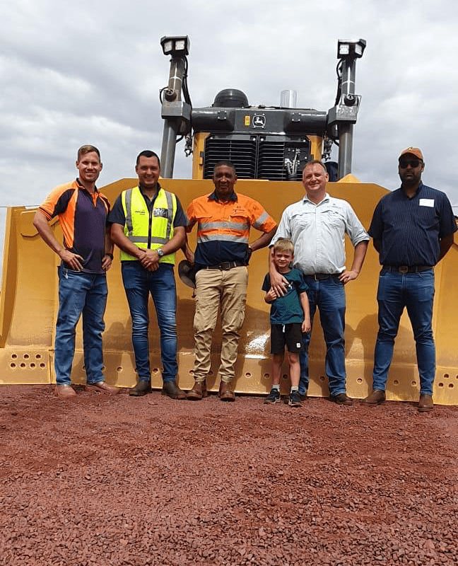 Jaco Botes and others from Moshaweng Mining together with an AFGRI Equipment representative standing in front of a John Deere dozer, highlighting reliable mining equipment and strong OEM partnership in South Africa.