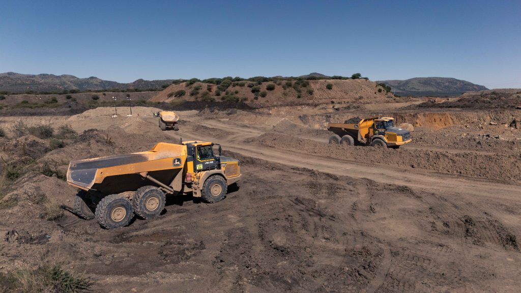 3 John Deere 460 ADTs part of a fleet of articulated dump trucks working in a newly established mining pit.