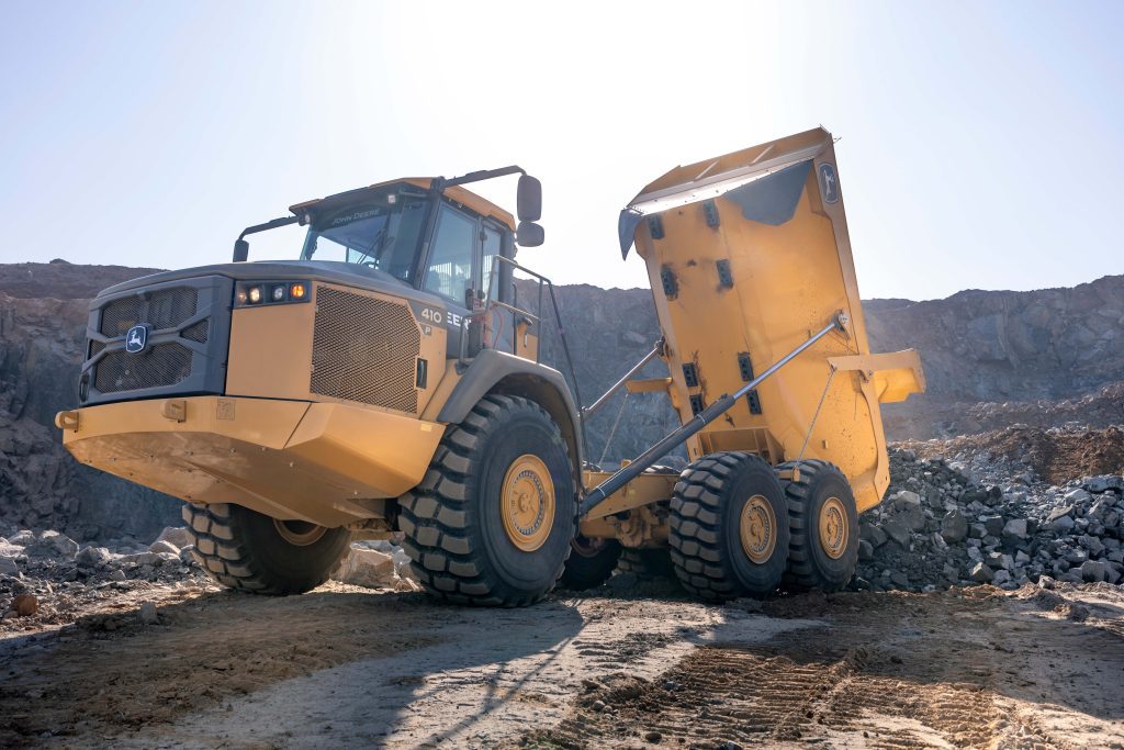 A photo of a John Deere 410 P-Tier ADT at 3/4angle with the bucket lifted.