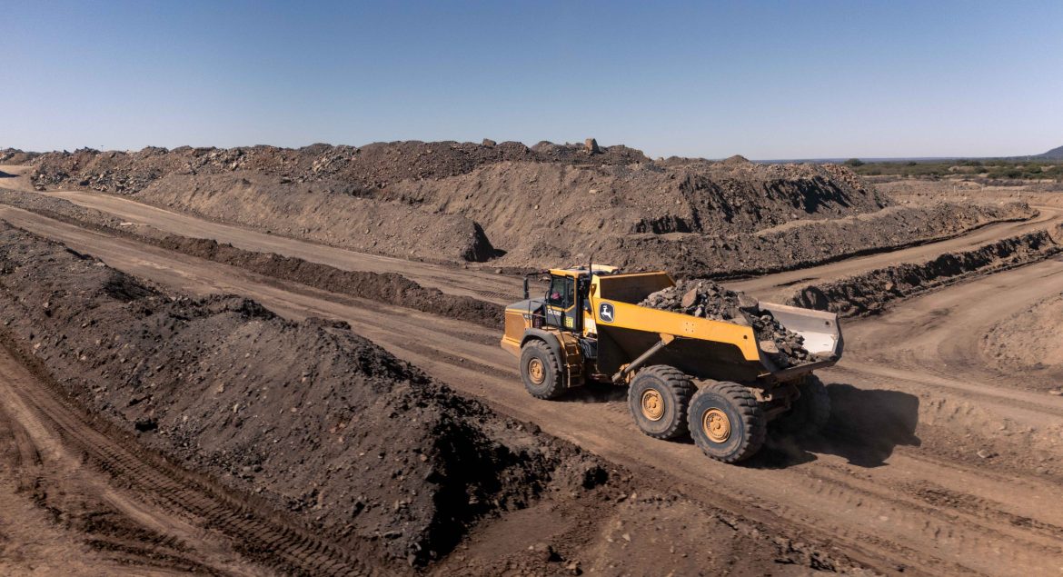 A John Deere 460 P-Tier Articulated dump truck transporting material across challenging mining terrain.