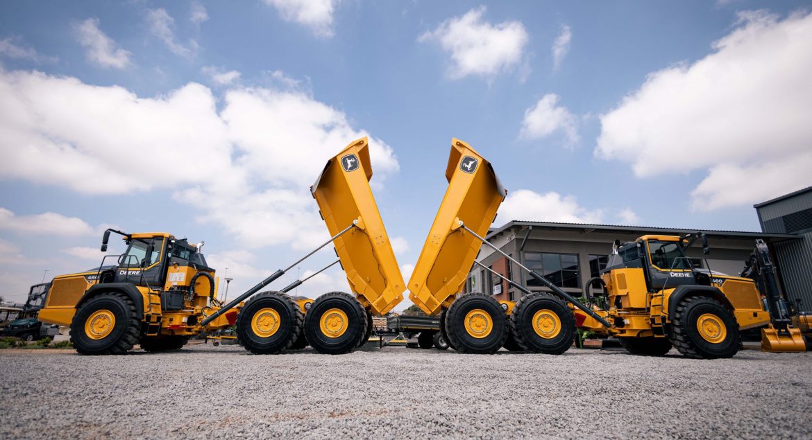 Two John Deere 460 P-Tier ADTs back-to-back with their buckets lifted. The Yellow Iron makes a nice contrast against the blue sky.