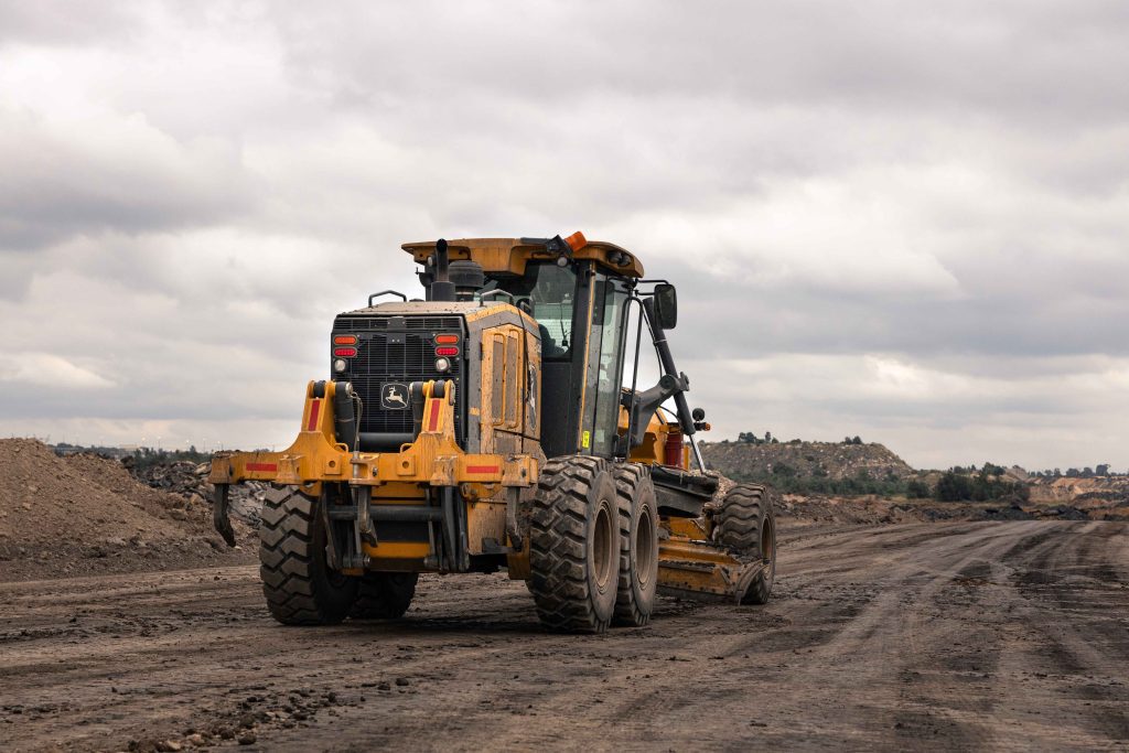 John Deere P-Tier motor grader equipped with advanced automation and joystick controls.