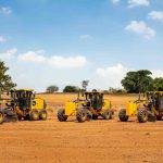 John Deere motor graders line-up, ready to perform precision grading on a road construction project.
