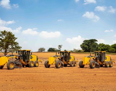 John Deere motor graders line-up, ready to perform precision grading on a road construction project.