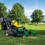 John Deere ZTrak zero turn mower parked on the grass on a well-maintained lawn.