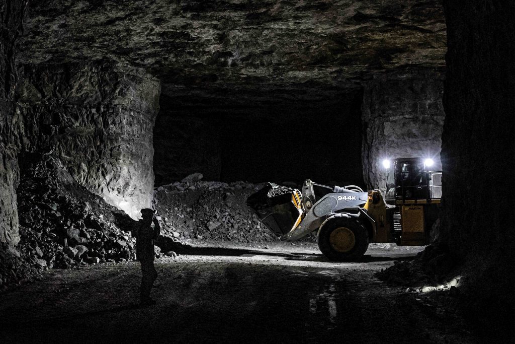 John Deere wheel loader carrying out underground trenching and utility installation work.