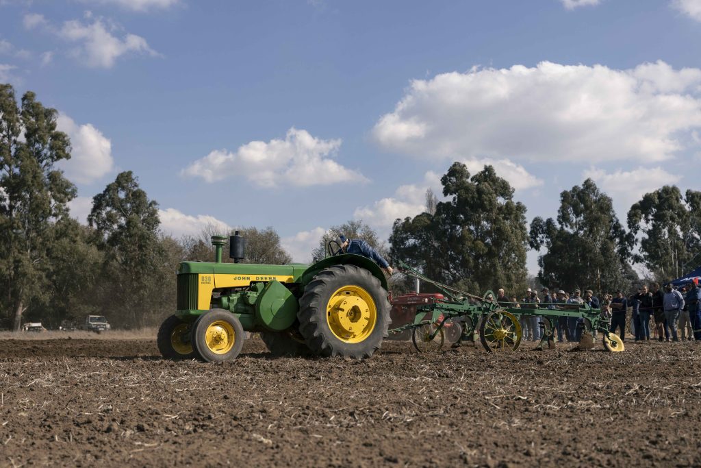 'n Ou John Deere 830 trekker met ou ploeg-implement tydens 'n lewendige demonstrasie by Val Boeredag.
